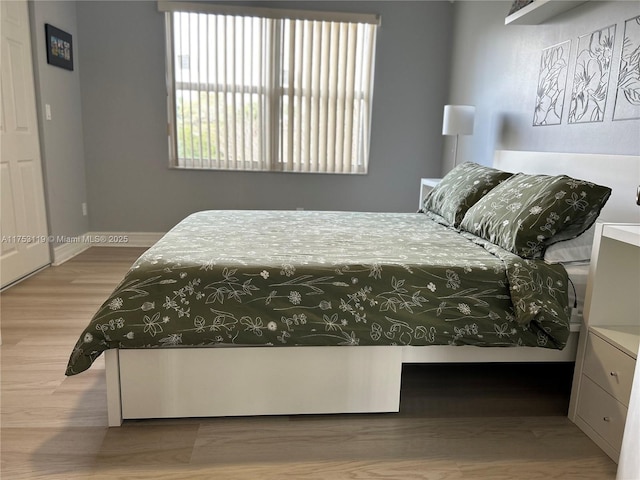 bedroom featuring wood finished floors and baseboards