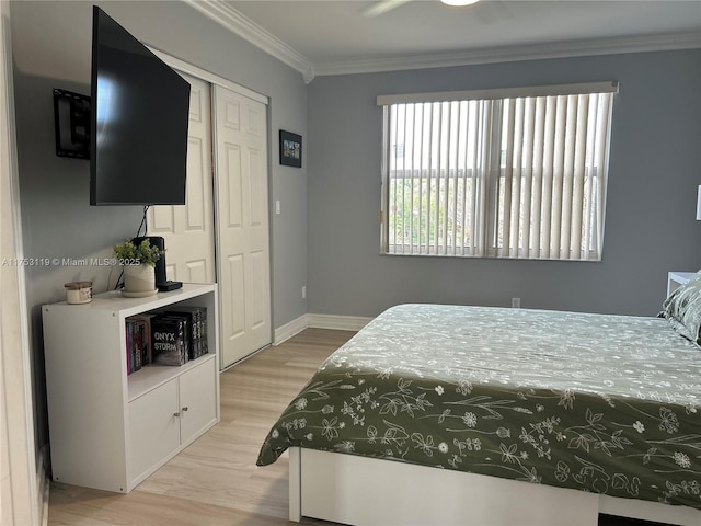 bedroom with ornamental molding, a closet, light wood-style flooring, and baseboards