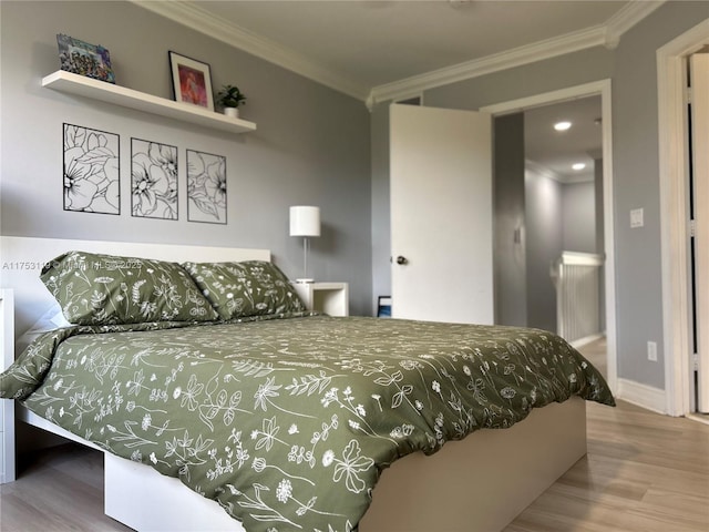 bedroom with crown molding, baseboards, and wood finished floors