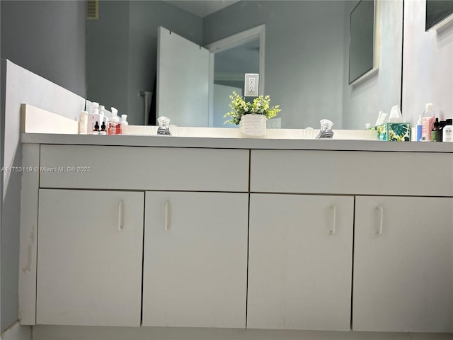 bathroom featuring visible vents, a sink, and double vanity