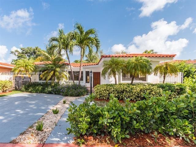 mediterranean / spanish house featuring a tiled roof and stucco siding