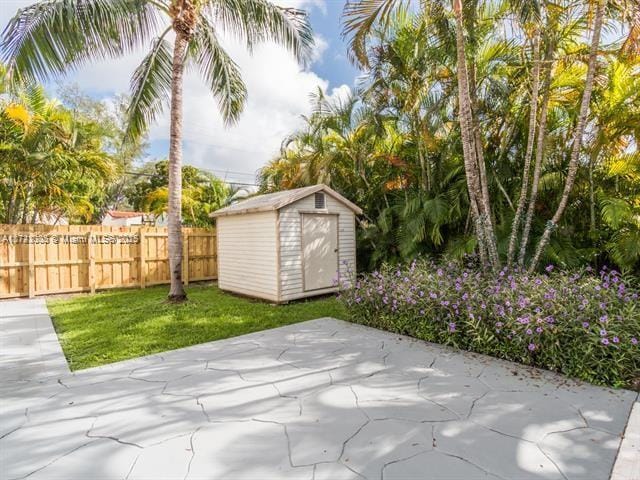 exterior space featuring fence, an outdoor structure, and a storage shed