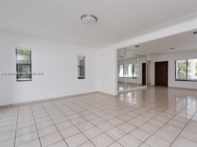 spare room with light tile patterned floors and baseboards