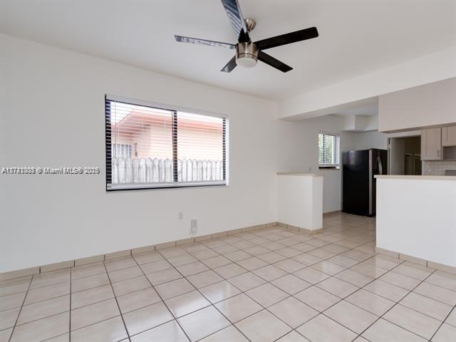 spare room with light tile patterned floors, ceiling fan, and baseboards