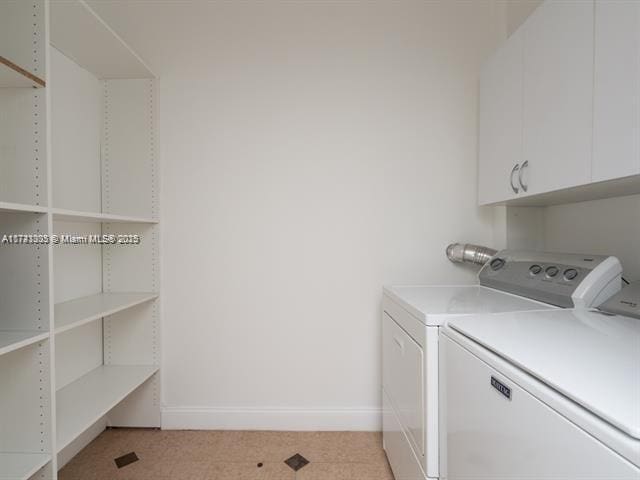 washroom featuring washer and dryer, cabinet space, and baseboards