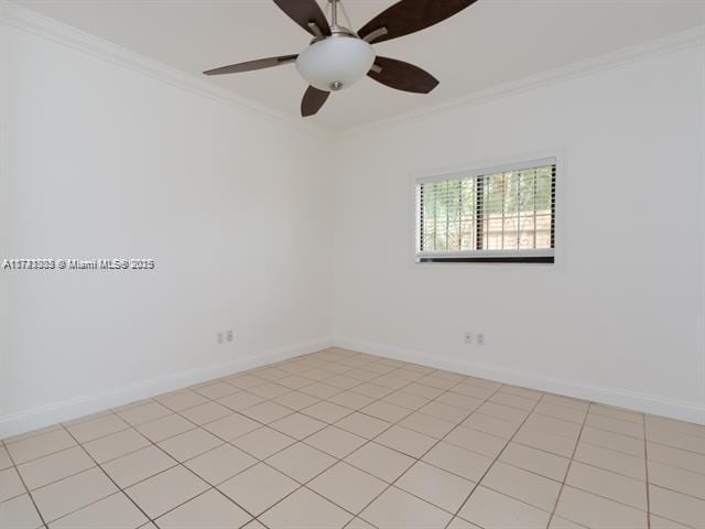 spare room with light tile patterned floors, ceiling fan, baseboards, and crown molding