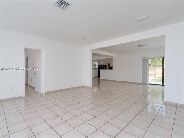 spare room featuring light tile patterned floors, baseboards, and visible vents