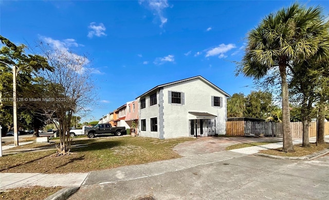 view of side of property with fence and stucco siding