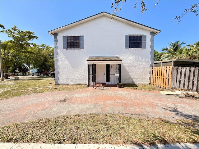 back of house featuring fence and stucco siding