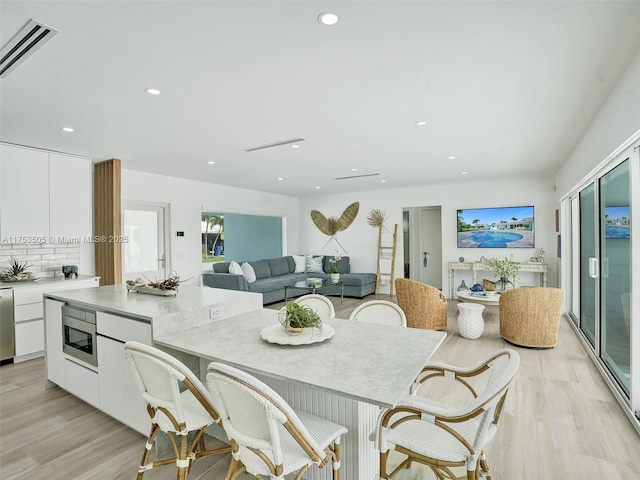 dining space with recessed lighting, visible vents, and light wood-style flooring