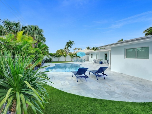 outdoor pool with fence private yard and a patio