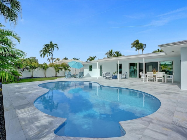 view of pool featuring a patio, outdoor dining area, fence, and a fenced in pool