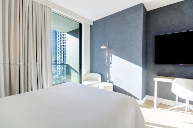 601 NE 1st Ave Unit 1706, Miami, FL 33132 - bedroom featuring an accent wall, wood finished floors, and baseboards