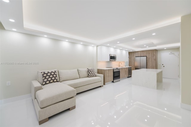 living room featuring recessed lighting and a raised ceiling