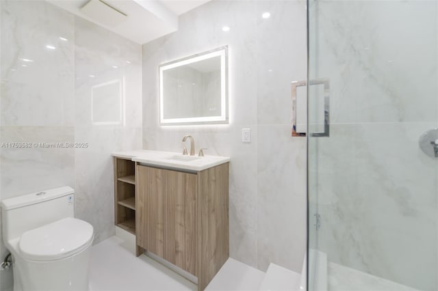 full bath with toilet, a marble finish shower, tile walls, and vanity