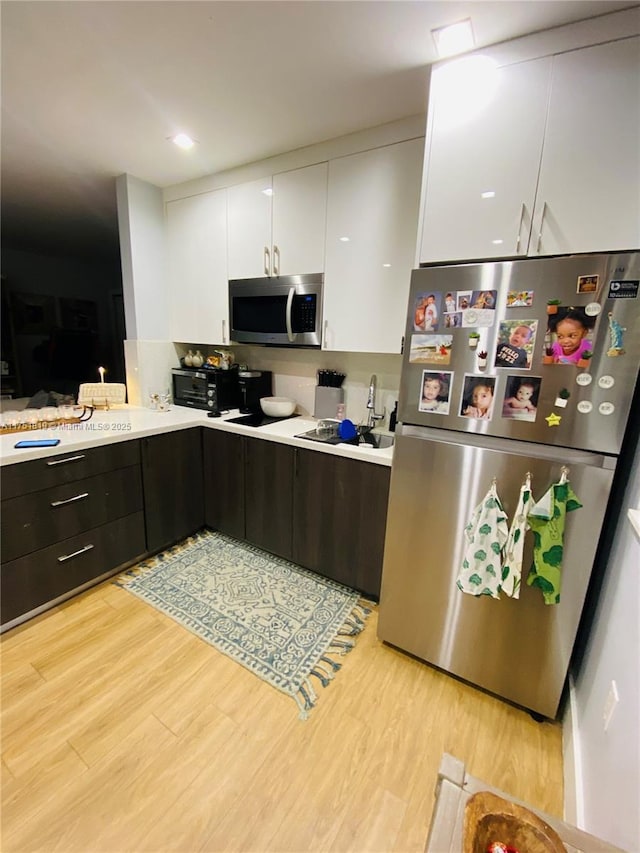 200 Azure Way, Miami Springs, FL 33166 - kitchen with light wood-style floors, white cabinetry, appliances with stainless steel finishes, and light countertops