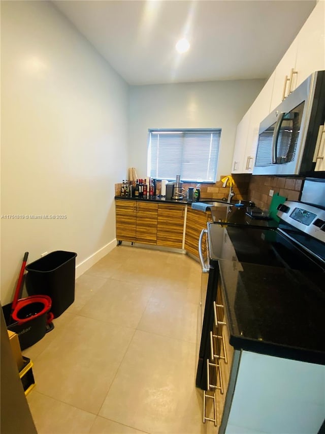 200 Azure Way, Miami Springs, FL 33166 - kitchen with stainless steel appliances, a sink, white cabinetry, baseboards, and dark countertops