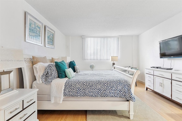 bedroom with light wood-style flooring and a textured ceiling