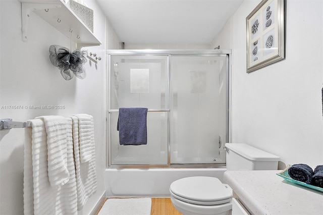 full bathroom with toilet, shower / bath combination with glass door, and wood finished floors