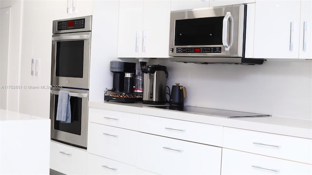 kitchen featuring appliances with stainless steel finishes, light countertops, and white cabinetry