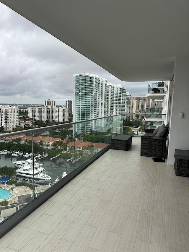 balcony featuring a water view and a city view