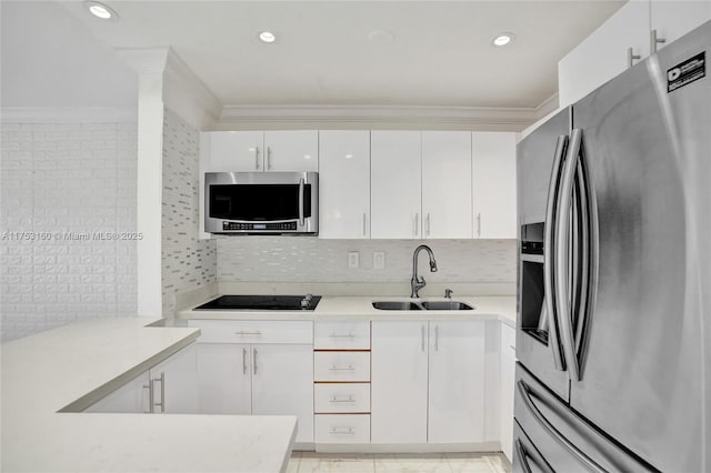 kitchen with stainless steel appliances, a sink, white cabinetry, and crown molding