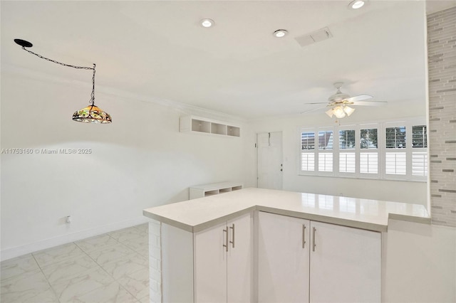 kitchen with pendant lighting, marble finish floor, light countertops, visible vents, and baseboards