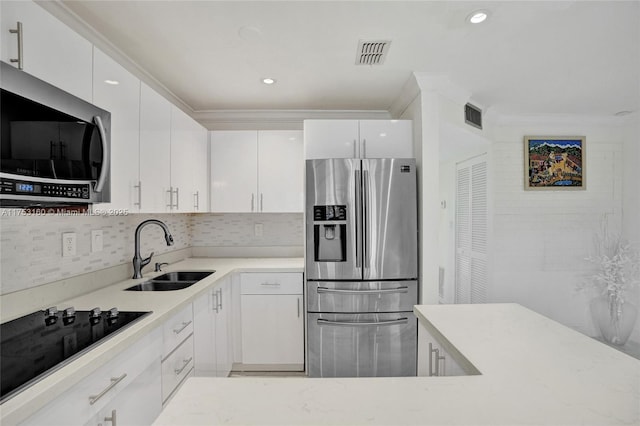 kitchen featuring visible vents, stainless steel appliances, a sink, and white cabinetry