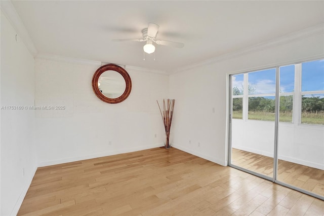 spare room featuring ornamental molding, light wood-style flooring, and baseboards