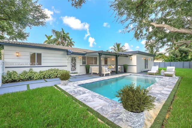 rear view of house featuring a patio, an outdoor hangout area, a tile roof, fence, and a fenced in pool