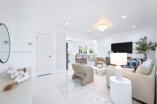 living area with baseboards, marble finish floor, and recessed lighting