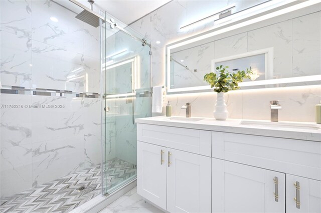 full bathroom featuring double vanity, marble finish floor, a marble finish shower, and a sink