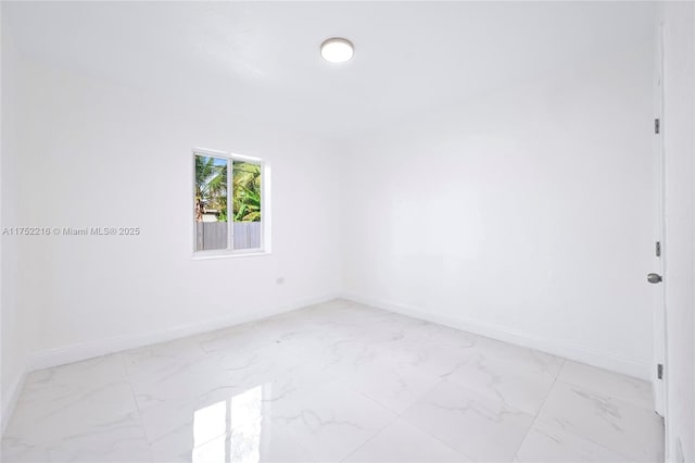 empty room with marble finish floor and baseboards