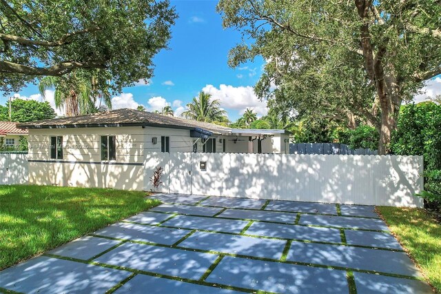 back of property featuring stucco siding, a fenced front yard, and a yard