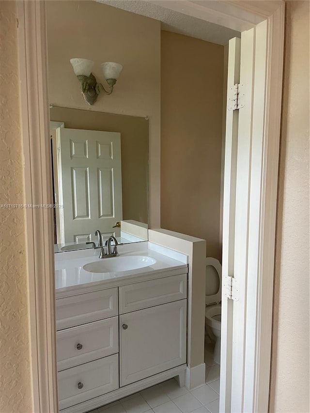 bathroom with toilet, tile patterned flooring, and vanity