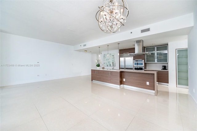 kitchen with stainless steel appliances, visible vents, island range hood, and modern cabinets