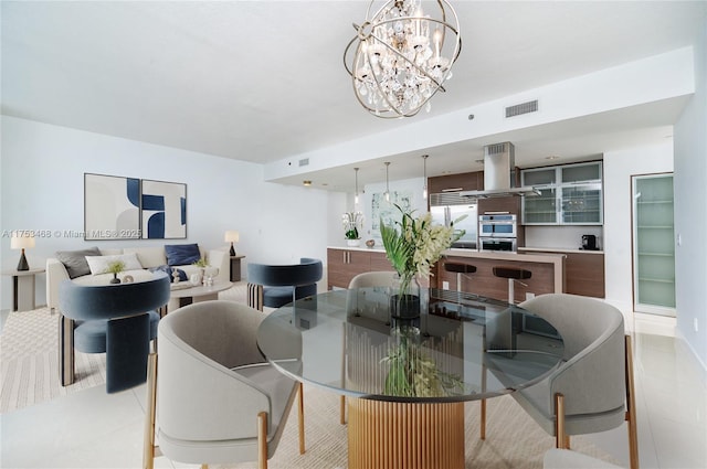 dining area featuring light tile patterned floors, visible vents, and an inviting chandelier