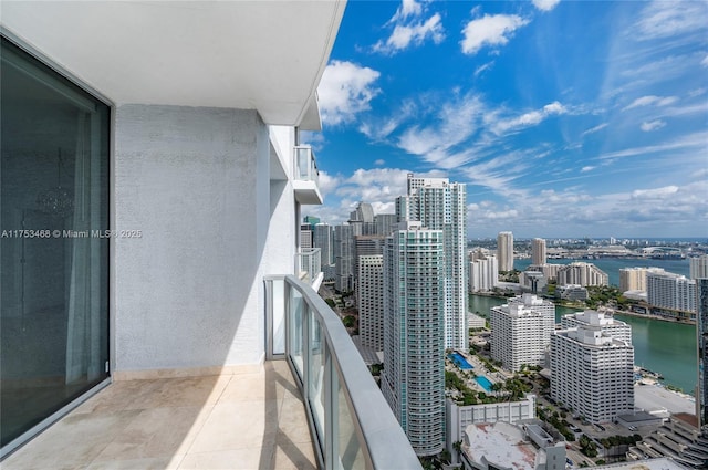 balcony featuring a water view and a city view