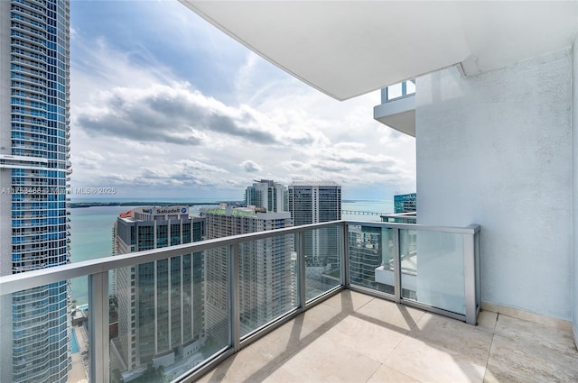 balcony with a water view and a view of city