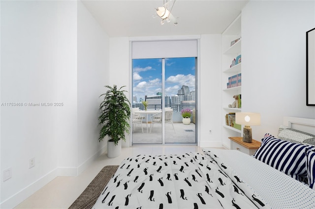 bedroom with baseboards, a city view, floor to ceiling windows, and access to exterior