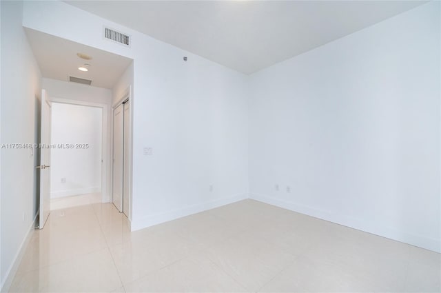 spare room featuring visible vents and baseboards