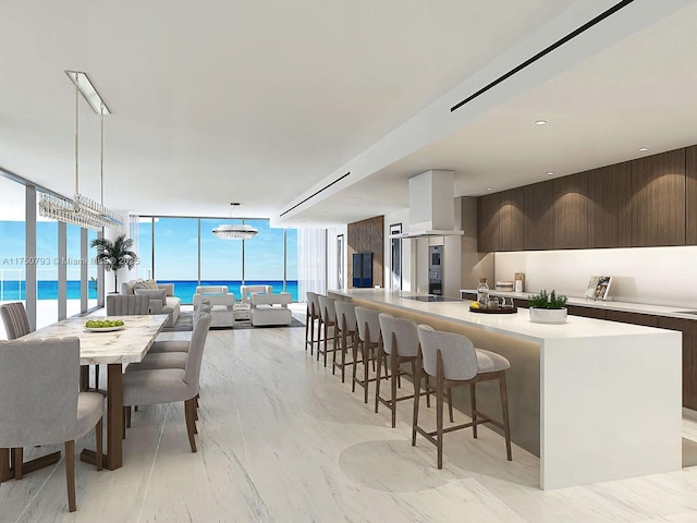 kitchen featuring dark brown cabinetry, modern cabinets, light countertops, a wall of windows, and a kitchen bar