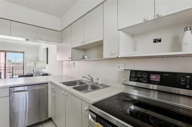 kitchen featuring stainless steel appliances, a sink, white cabinets, light countertops, and open shelves