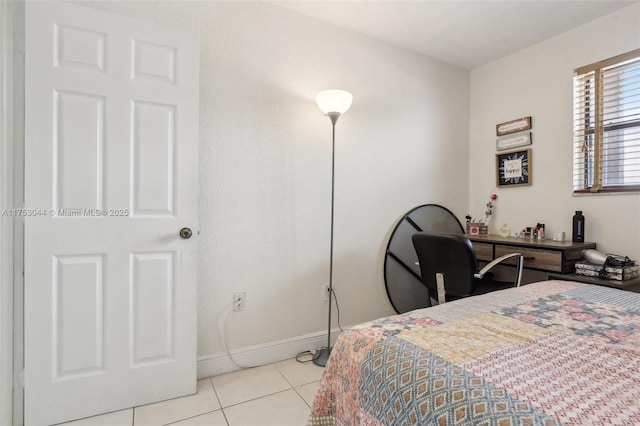 bedroom with light tile patterned floors and baseboards