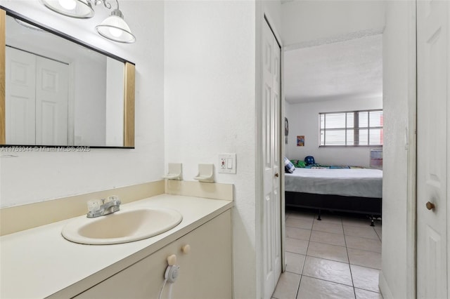 ensuite bathroom with ensuite bathroom, vanity, and tile patterned floors