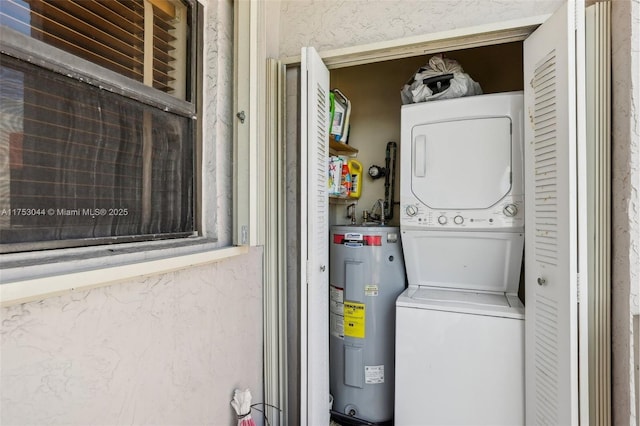 laundry area with laundry area, stacked washing maching and dryer, and electric water heater