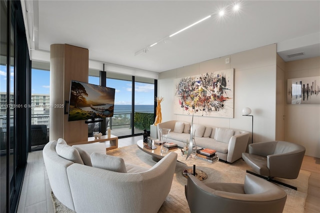 living room with expansive windows, visible vents, and wood finished floors