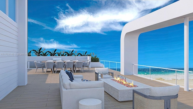 view of patio featuring a view of the beach, outdoor dining space, an outdoor living space with a fire pit, and a water view