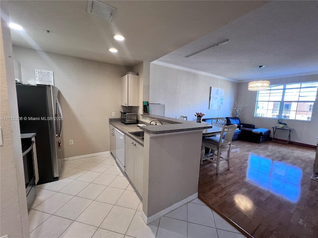 kitchen featuring white cabinets, a peninsula, crown molding, a sink, and light tile patterned flooring