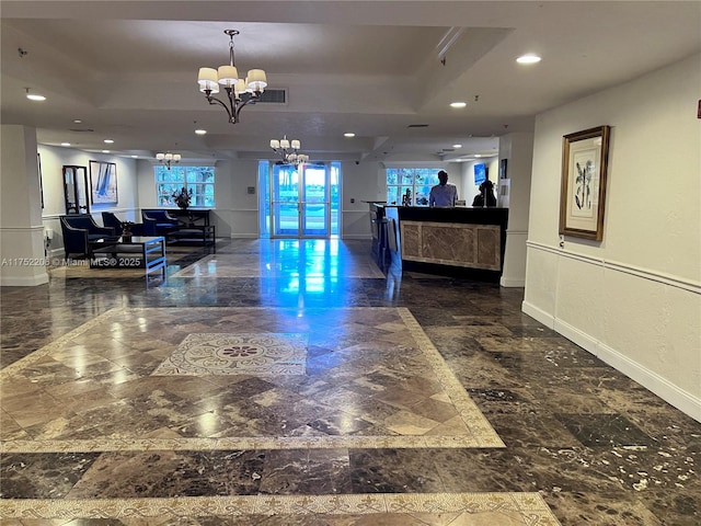 reception featuring visible vents and a notable chandelier